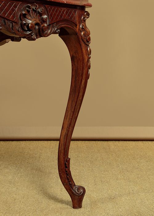 A late nineteenth-century carved walnut centre table with cabriole legs, Rococo frieze carving, and a rouge marble top. View IX