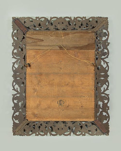 A rectangular dark oak wall mirror featuring intricate openwork carvings of grapevines and leaves framing a bevelled glass plate. View VIII