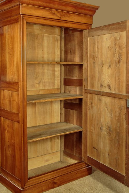 A single-door antique French Louis Philippe cherrywood wardrobe with figured timber grain and a moulded cornice. View IX
