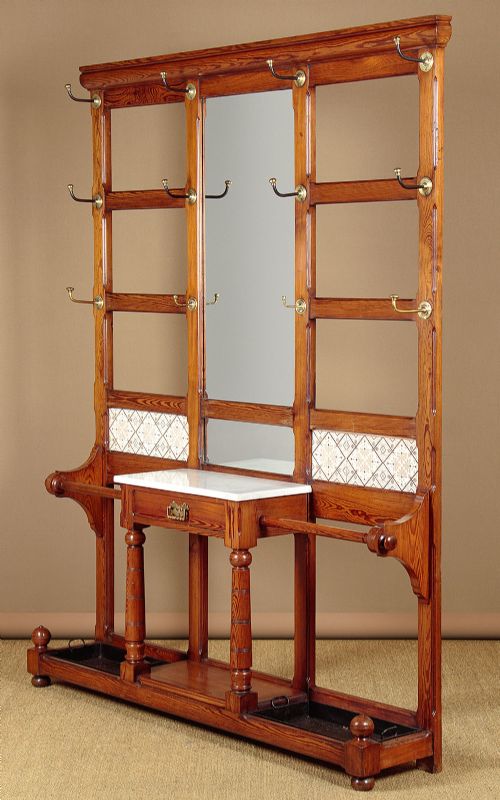 A large Victorian pine hallstand featuring a central vertical mirror, multiple brass coat hooks, inset ceramic tiles, a marble-topped glove drawer, and lower umbrella stand trays. View II