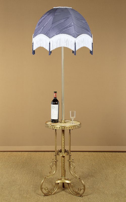 An Edwardian brass standard lamp featuring an integrated circular onyx wine table with a pierced gallery trim atop a scrolling tripod base. View II