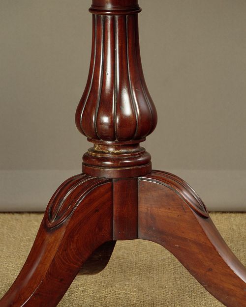 A mahogany three-tier dumb waiter featuring graduated circular trays supported by fluted central columns on a tripod base with brass castors. View VIII