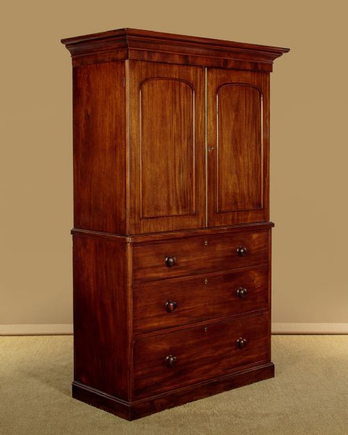 A mid-19th century mahogany linen press featuring two arched panel doors over three full-width drawers with turned wooden handles. View II