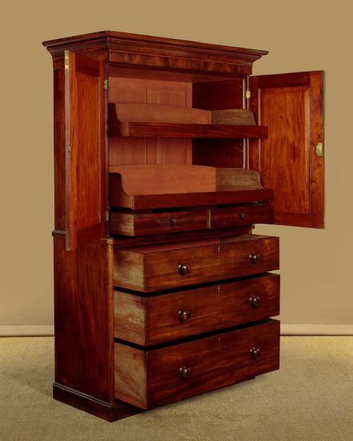 A mid-19th century mahogany linen press featuring two arched panel doors over three full-width drawers with turned wooden handles. View IV