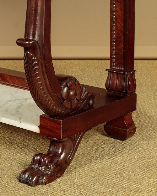 A 19th-century mahogany console table with a white marble top, lower marble tier, carved scroll legs, and paw feet. View X