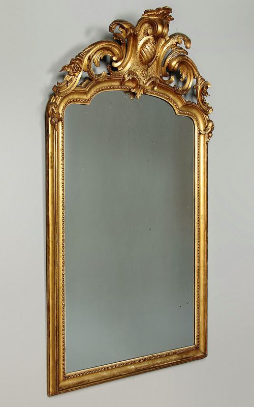 A large late Victorian giltwood overmantel mirror with an arched top, detailed beaded inner rim, and carved cresting featuring acanthus scrollwork. View II