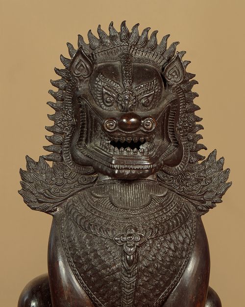 A pair of dark bronze temple lion statues sitting upright with intricate stylized manes and detailed ornamental chest bands. View VI