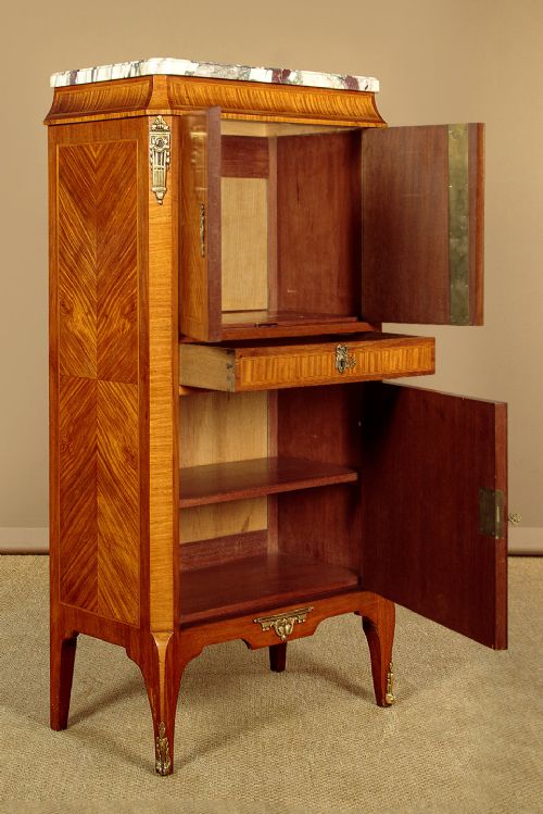 A tall Louis XVI style wooden side cabinet featuring geometric herringbone parquetry veneers, brass mounts, and a polished marble top. View V