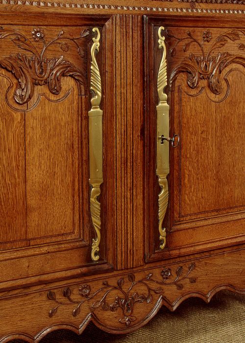 A late 18th-century French oak dresser base featuring two drawers above carved panelled cupboard doors with brass hardware. View VIII