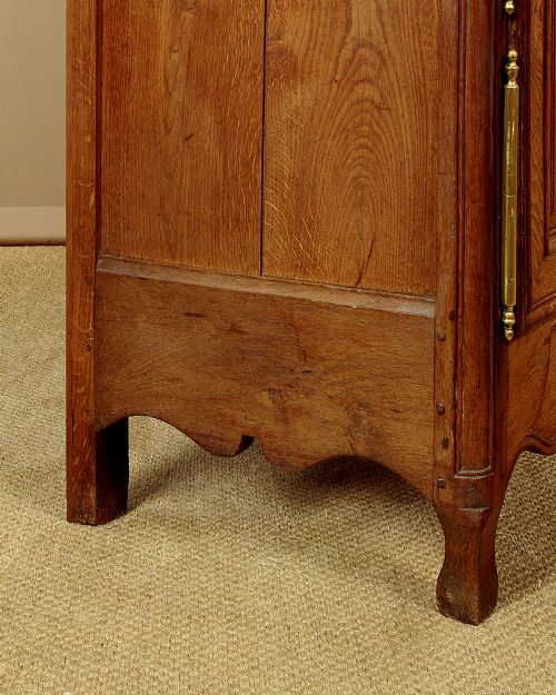 A late 18th-century French oak dresser base featuring two drawers above carved panelled cupboard doors with brass hardware. View XIII