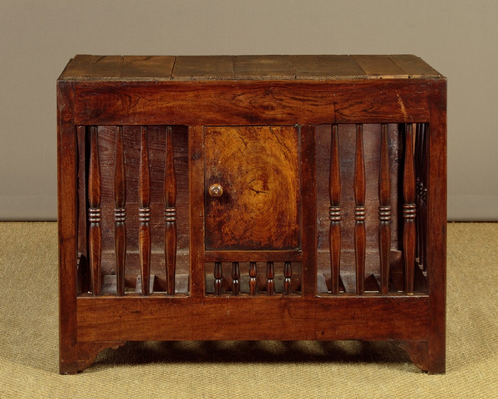 A 19th-century French provincial wooden bread safe featuring turned spindles, a central panelled door, and a warm brown timber finish.