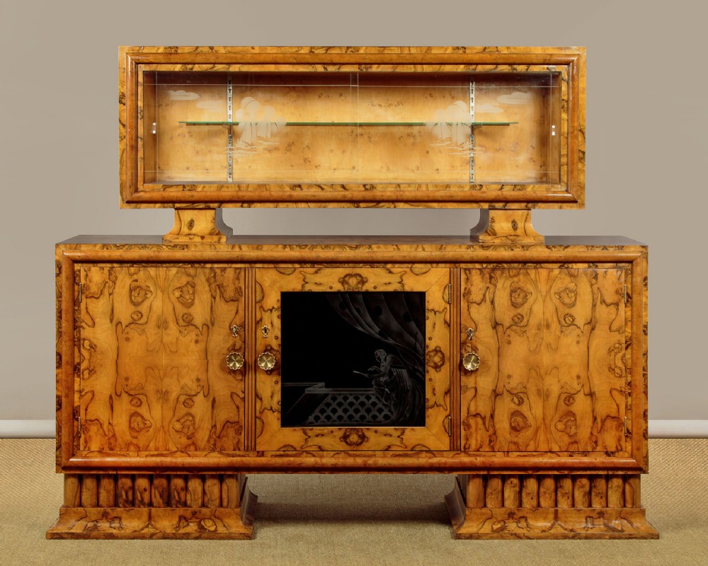 An Italian Art Deco burr walnut sideboard featuring an upper glass display cabinet, etched glass center door, brass hardware, and a stepped base.