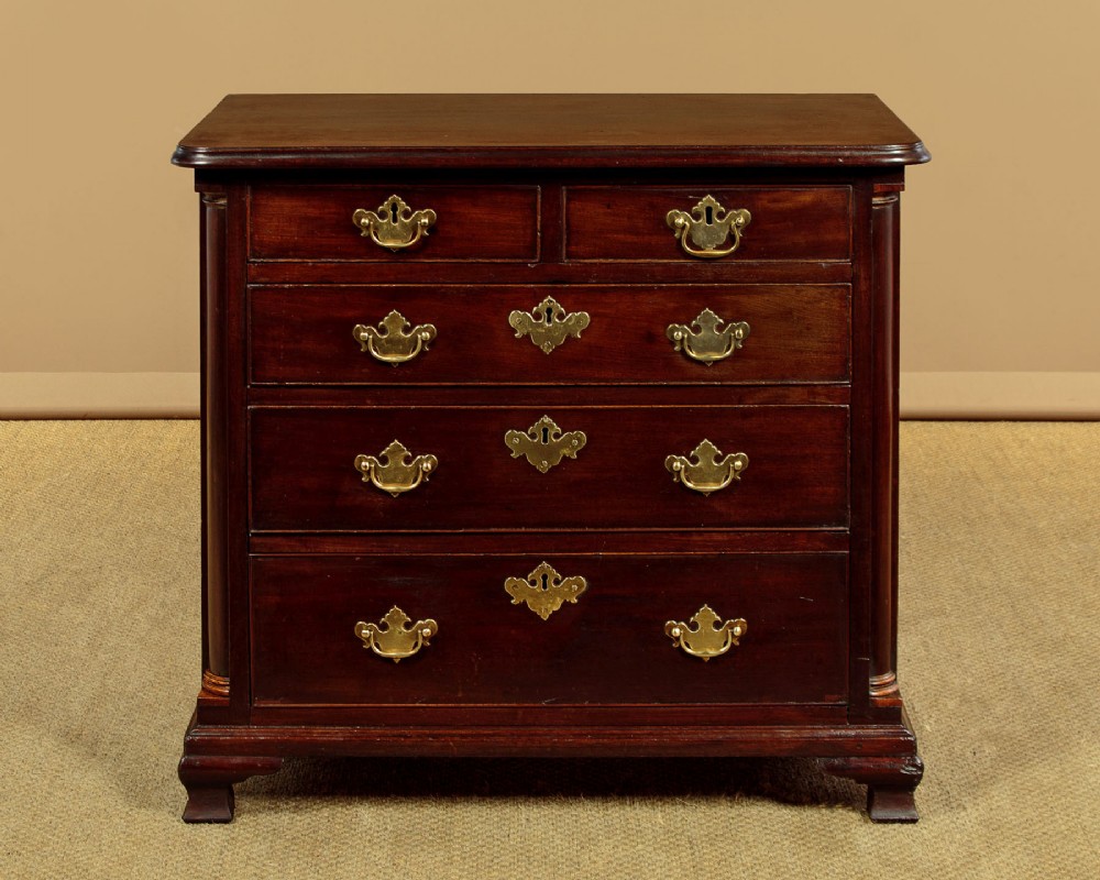 A late 18th-century Georgian mahogany chest of drawers with two short over three long graduated drawers, brass handles, and bracket feet.