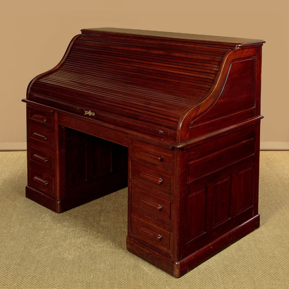 An Edwardian dark walnut roll top desk with a open slatted tambour shutter revealing interior drawers and pigeonholes above twin pedestal bases. View IV