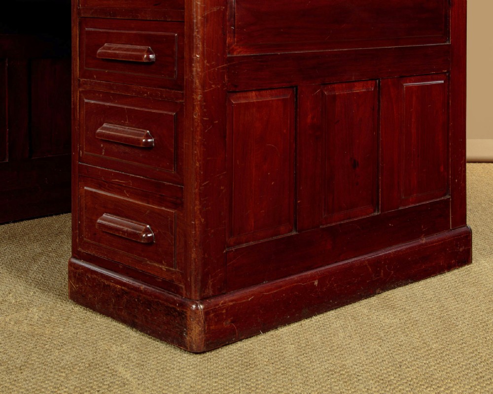 An Edwardian dark walnut roll top desk with a open slatted tambour shutter revealing interior drawers and pigeonholes above twin pedestal bases. View XI