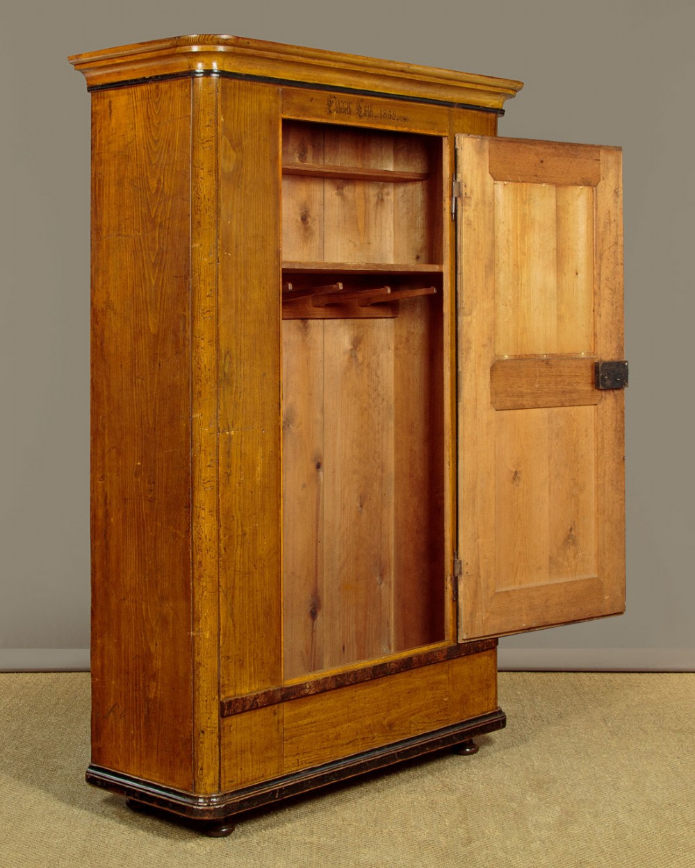 A single-door pine wardrobe featuring hand-painted urn motifs on two panelled sections and a dated inscription near the moulded cornice. View III
