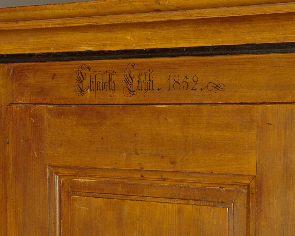 A single-door pine wardrobe featuring hand-painted urn motifs on two panelled sections and a dated inscription near the moulded cornice. View V