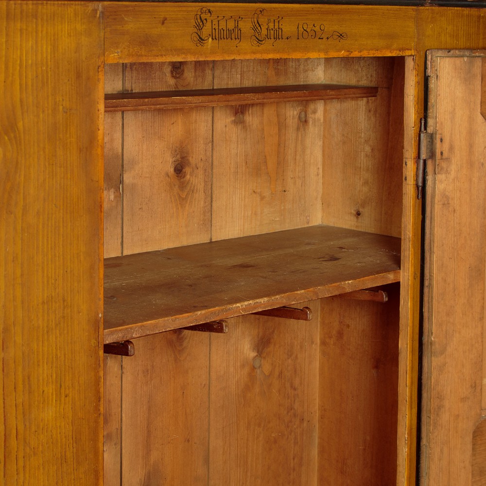 A single-door pine wardrobe featuring hand-painted urn motifs on two panelled sections and a dated inscription near the moulded cornice. View XI