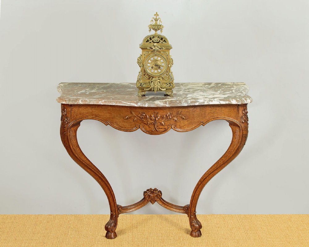 An oak console table featuring a shaped grey marble top, floral relief carvings along the apron, exaggerated cabriole legs, and a scrolled stretcher. View II