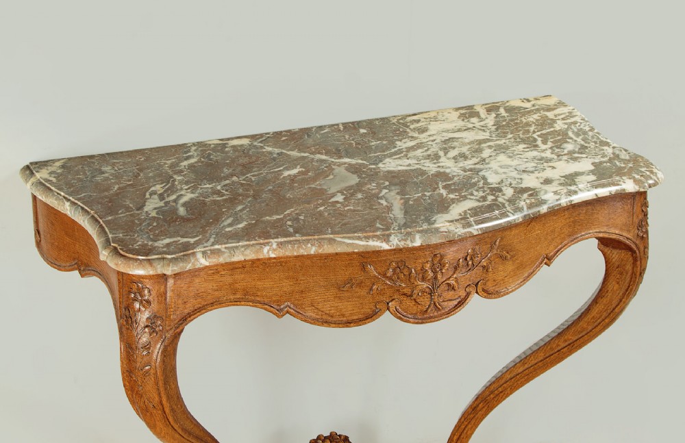 An oak console table featuring a shaped grey marble top, floral relief carvings along the apron, exaggerated cabriole legs, and a scrolled stretcher. View IV