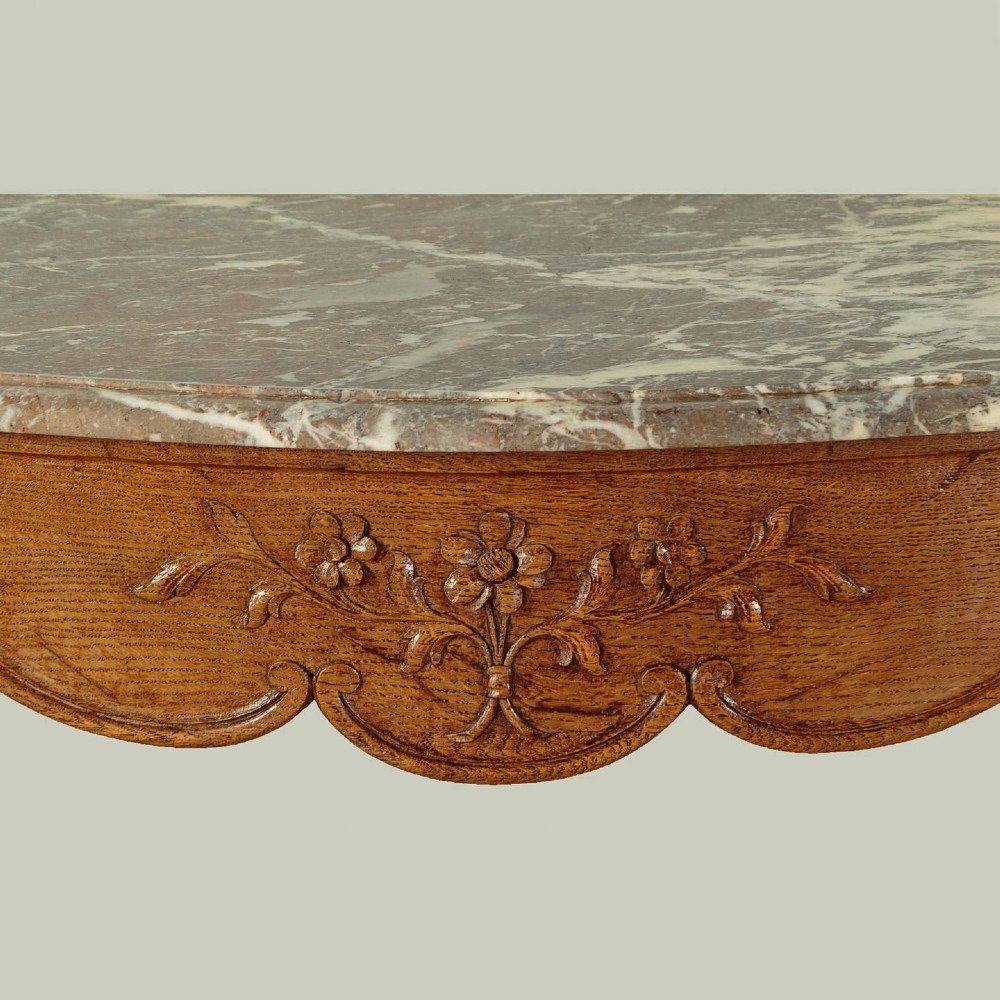 An oak console table featuring a shaped grey marble top, floral relief carvings along the apron, exaggerated cabriole legs, and a scrolled stretcher. View VI