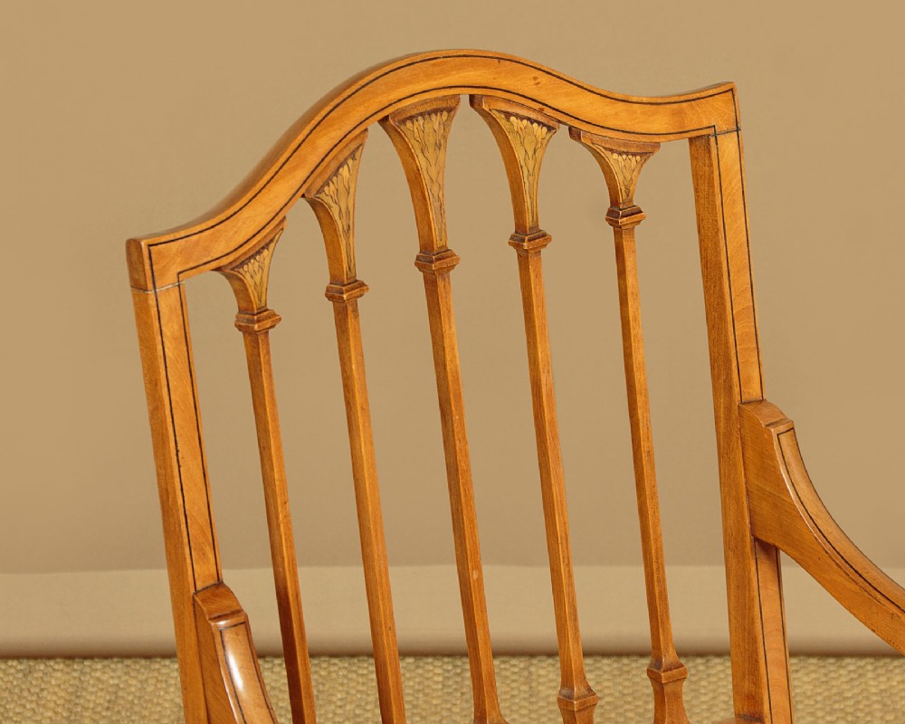 A pair of inlaid satinwood armchairs featuring arched spindle backrests and pink plaid upholstered seats. View V