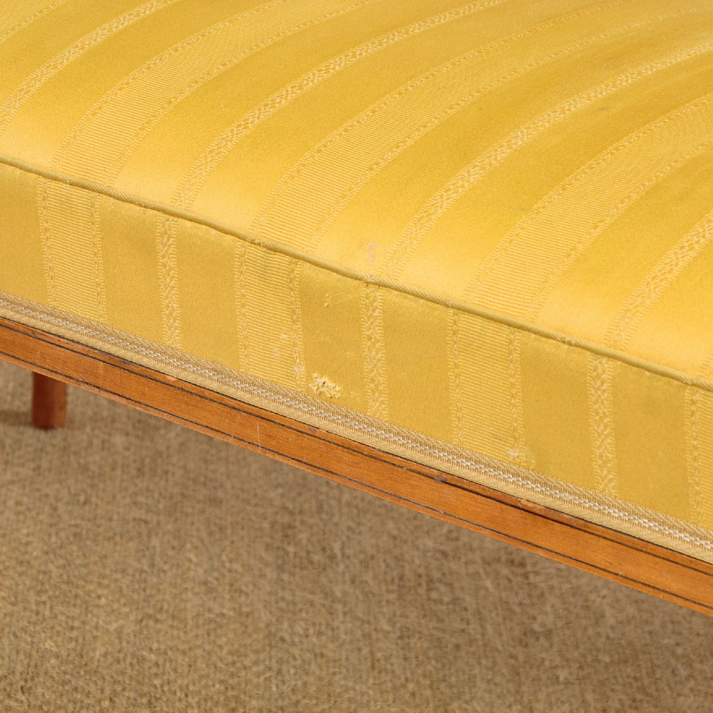 An antique inlaid satinwood triple chair-back settee featuring vertical splats, sweeping arms, and a yellow striped upholstered seat. View X