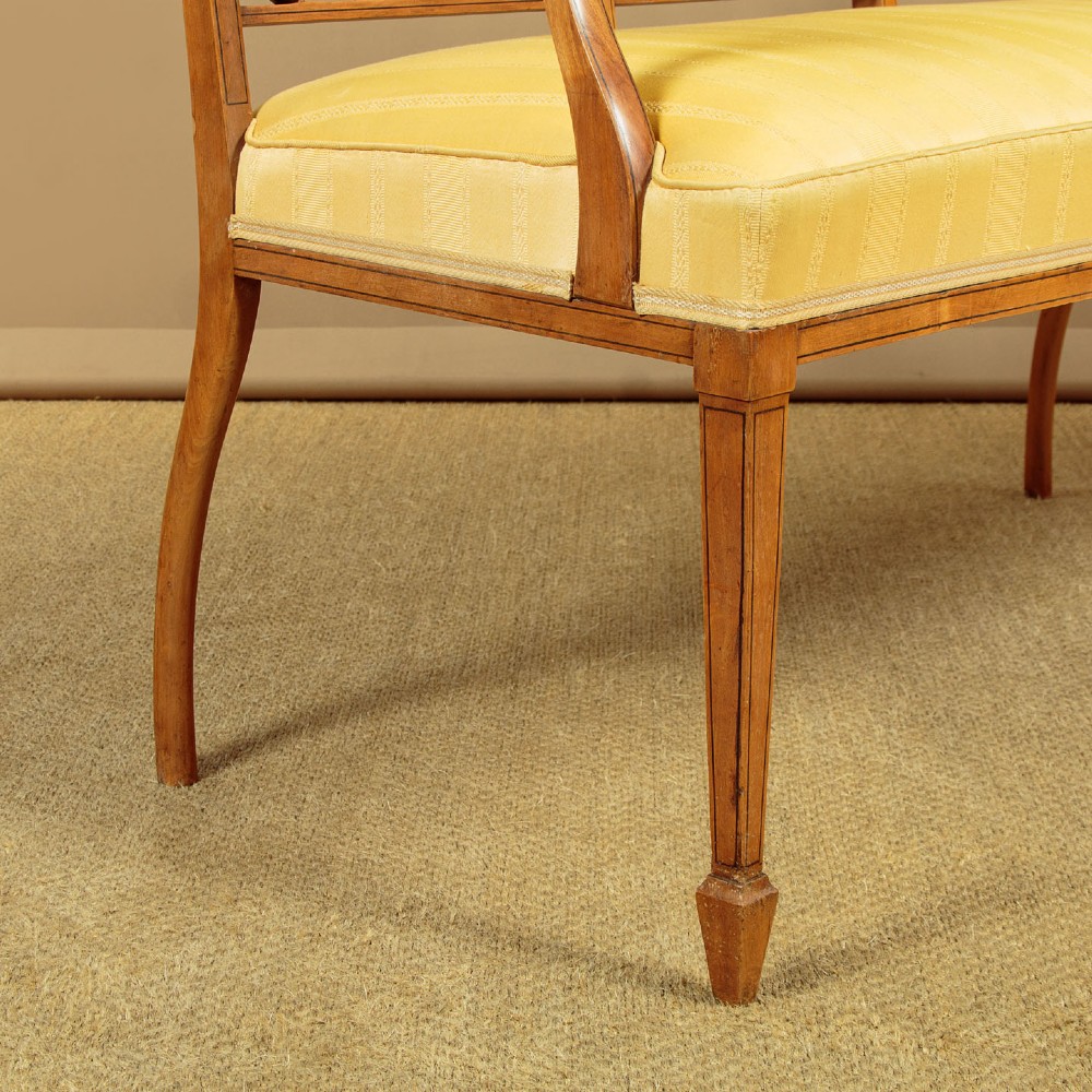 An antique inlaid satinwood triple chair-back settee featuring vertical splats, sweeping arms, and a yellow striped upholstered seat. View XI