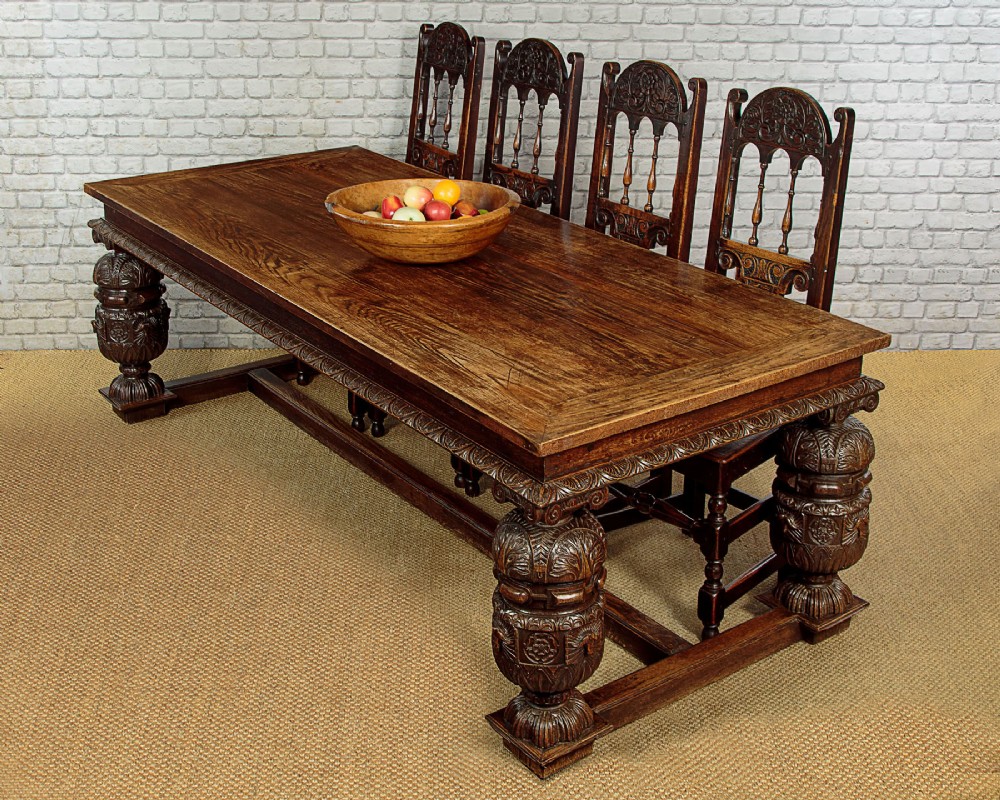 A large dark oak refectory dining table featuring heavily carved bulbous turned legs, an ornate frieze, and low stretchers. View II
