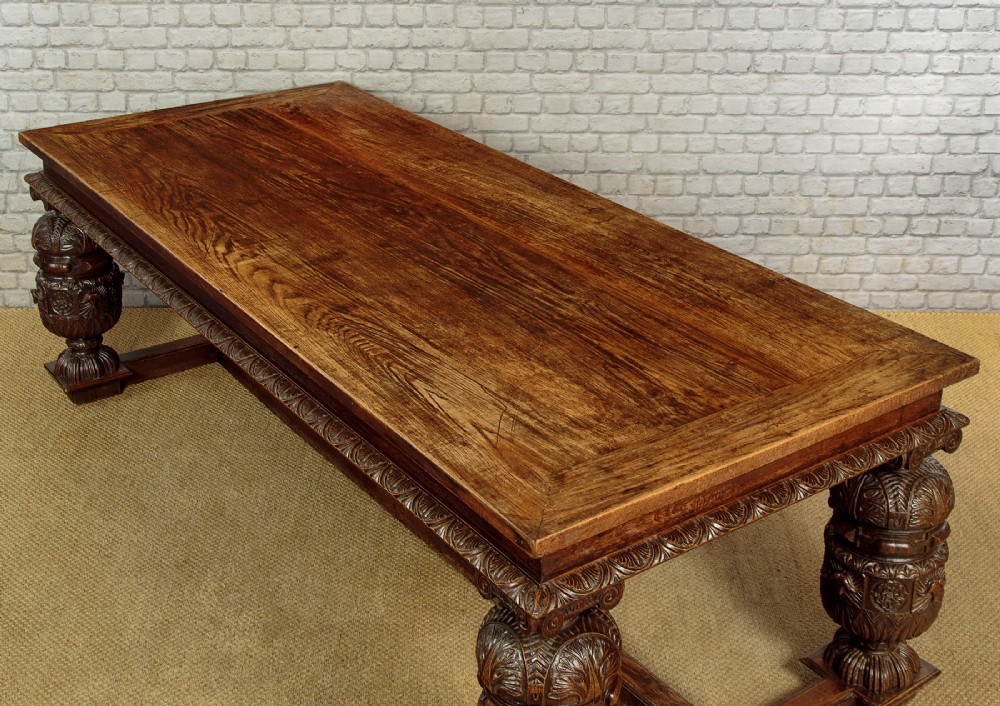 A large dark oak refectory dining table featuring heavily carved bulbous turned legs, an ornate frieze, and low stretchers. View IV