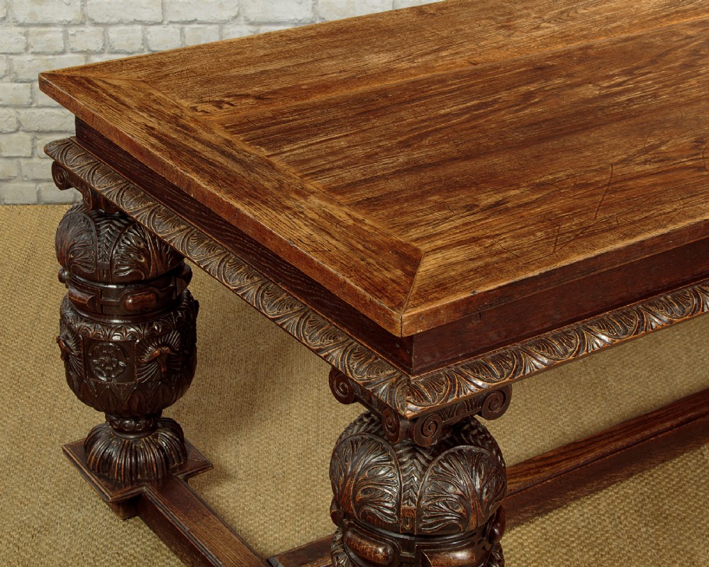 A large dark oak refectory dining table featuring heavily carved bulbous turned legs, an ornate frieze, and low stretchers. View V