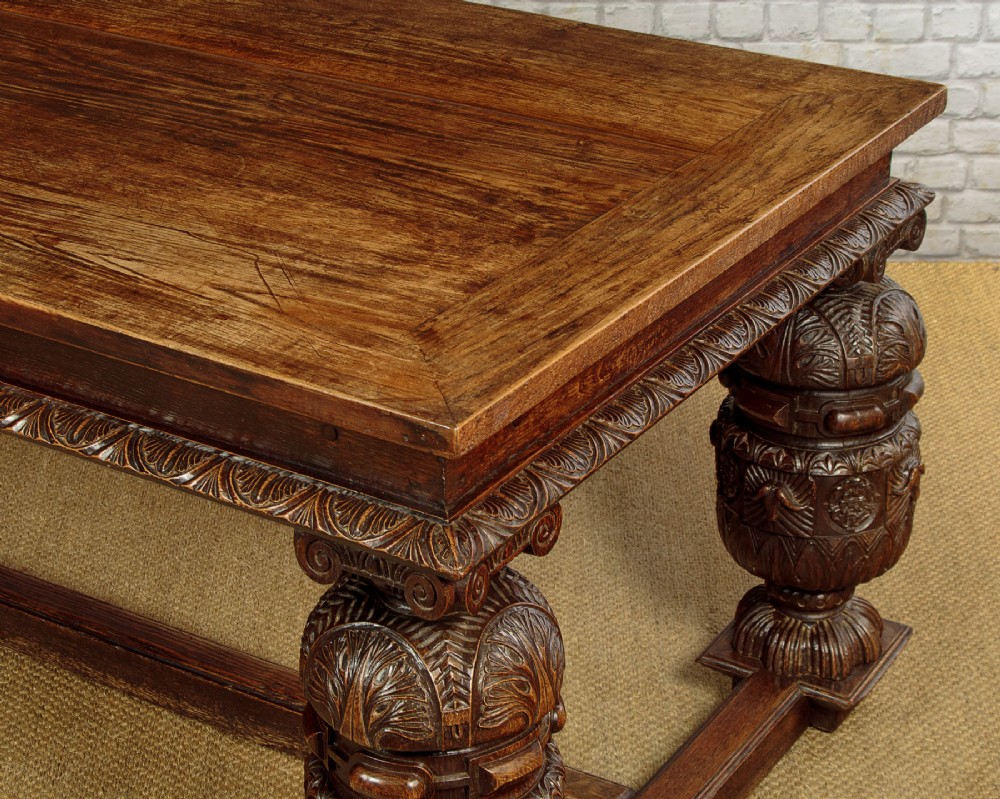 A large dark oak refectory dining table featuring heavily carved bulbous turned legs, an ornate frieze, and low stretchers. View VI