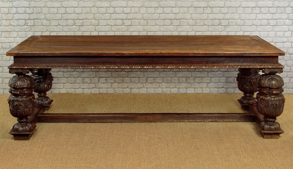 A large dark oak refectory dining table featuring heavily carved bulbous turned legs, an ornate frieze, and low stretchers. View VII