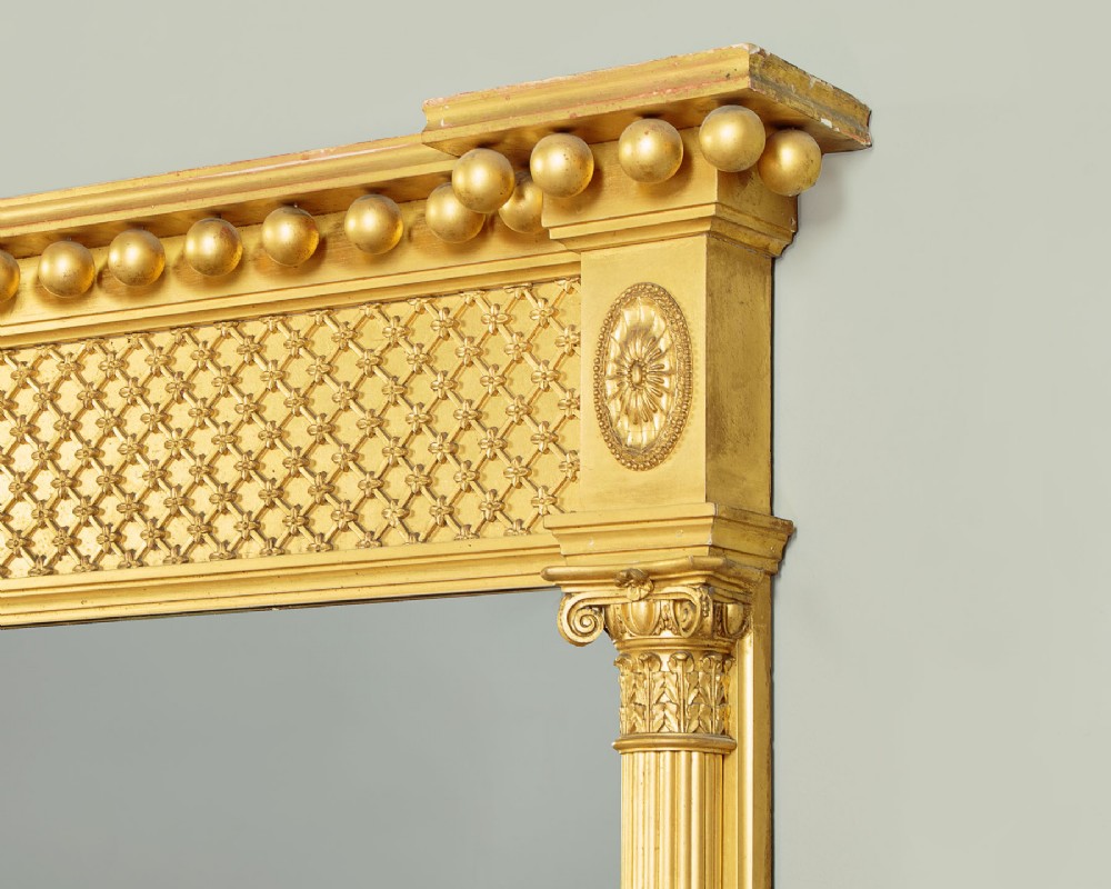 A large rectangular giltwood overmantel mirror featuring a decorated upper frieze with spherical mouldings and fluted side columns. View III