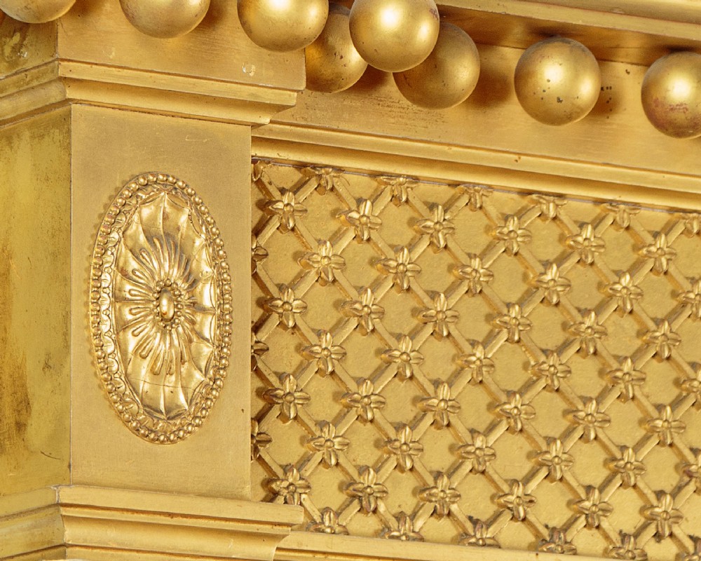 A large rectangular giltwood overmantel mirror featuring a decorated upper frieze with spherical mouldings and fluted side columns. View V