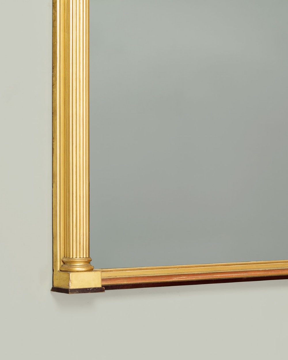 A large rectangular giltwood overmantel mirror featuring a decorated upper frieze with spherical mouldings and fluted side columns. View VII
