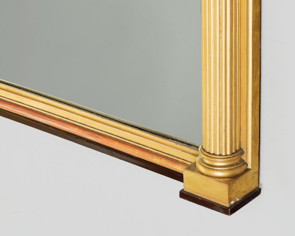 A large rectangular giltwood overmantel mirror featuring a decorated upper frieze with spherical mouldings and fluted side columns. View VIII