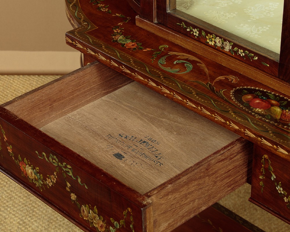 A dark mahogany display cabinet featuring hand-painted floral swags, classical urns, glass side panels, twin glazed doors, and tapered legs with an undertier. View X