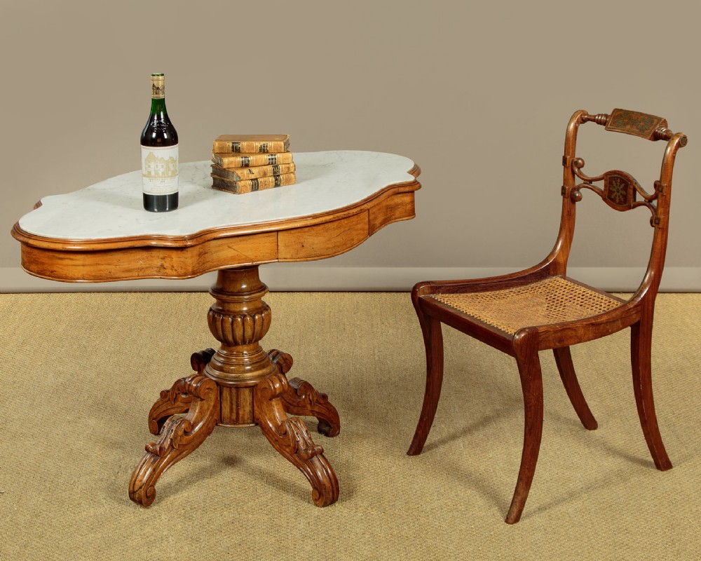 A nineteenth-century Victorian walnut centre table featuring a serpentine white marble top resting on a carved pedestal stem with scrolled tripod legs. View II