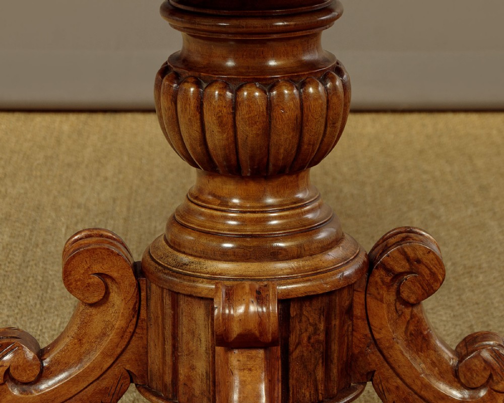 A nineteenth-century Victorian walnut centre table featuring a serpentine white marble top resting on a carved pedestal stem with scrolled tripod legs. View VIII
