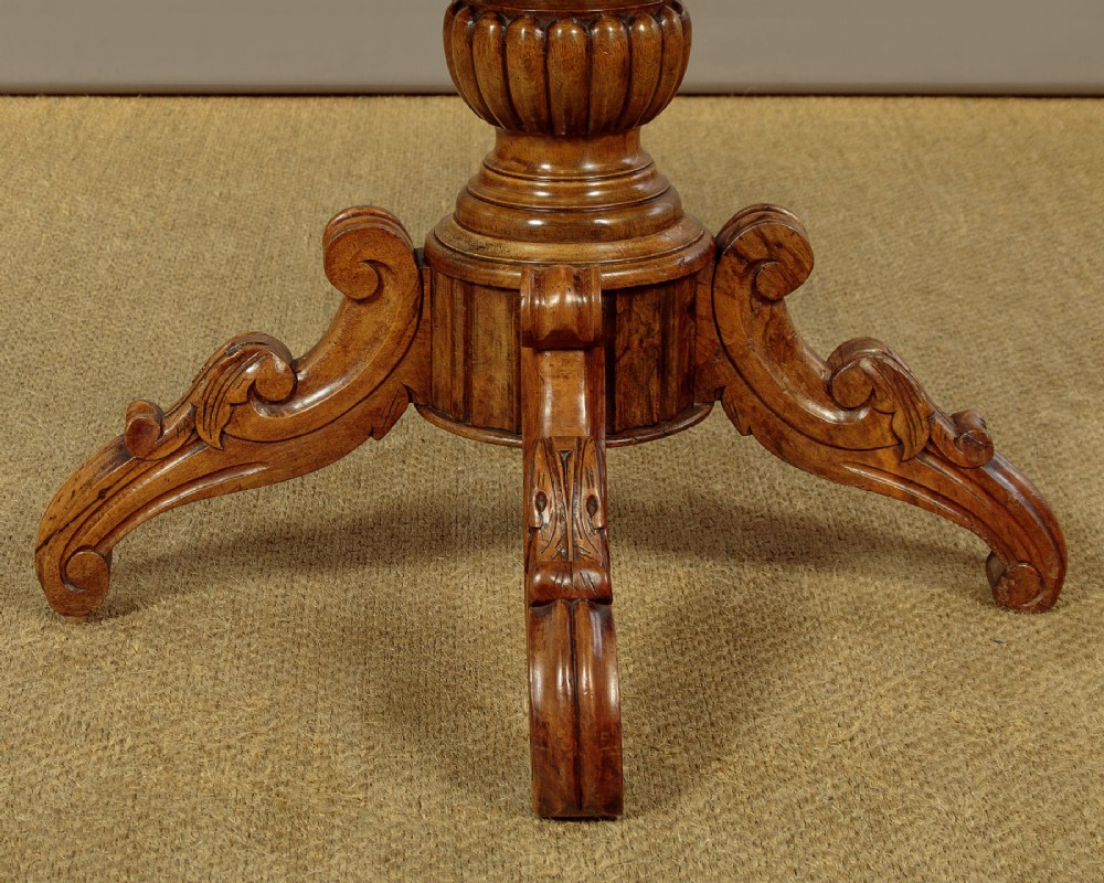 A nineteenth-century Victorian walnut centre table featuring a serpentine white marble top resting on a carved pedestal stem with scrolled tripod legs. View IX