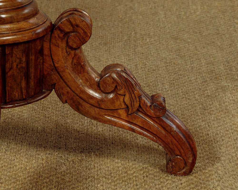A nineteenth-century Victorian walnut centre table featuring a serpentine white marble top resting on a carved pedestal stem with scrolled tripod legs. View X