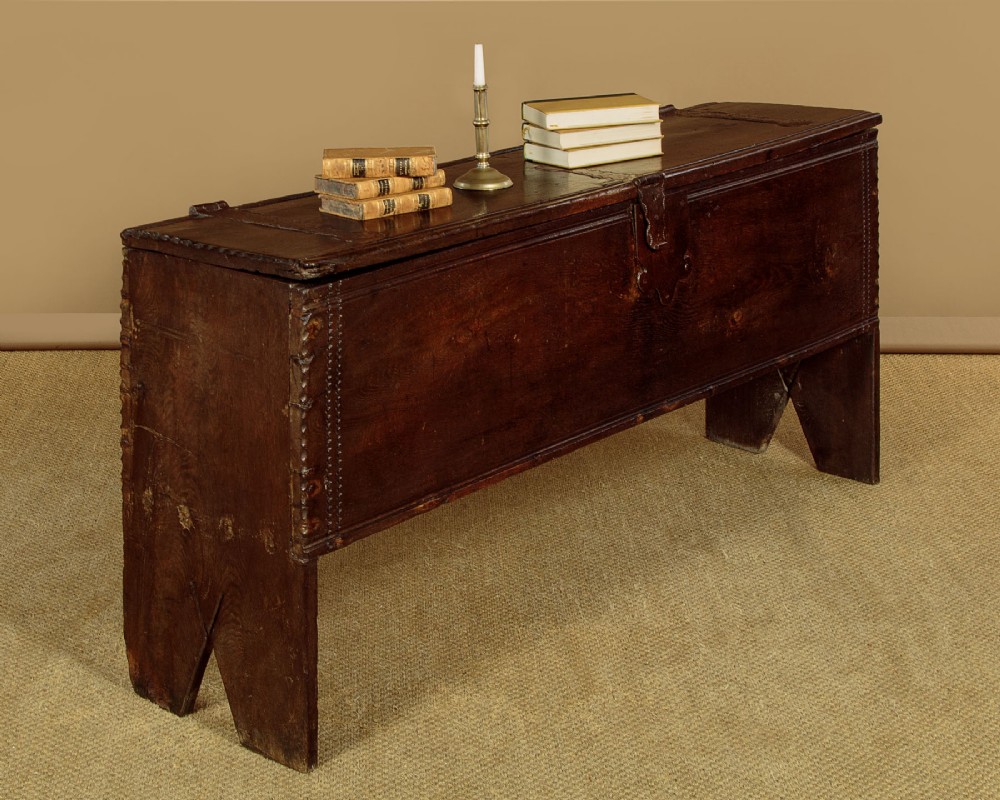 A long dark oak boarded sword chest featuring iron strap hinges and slab end supports. View II