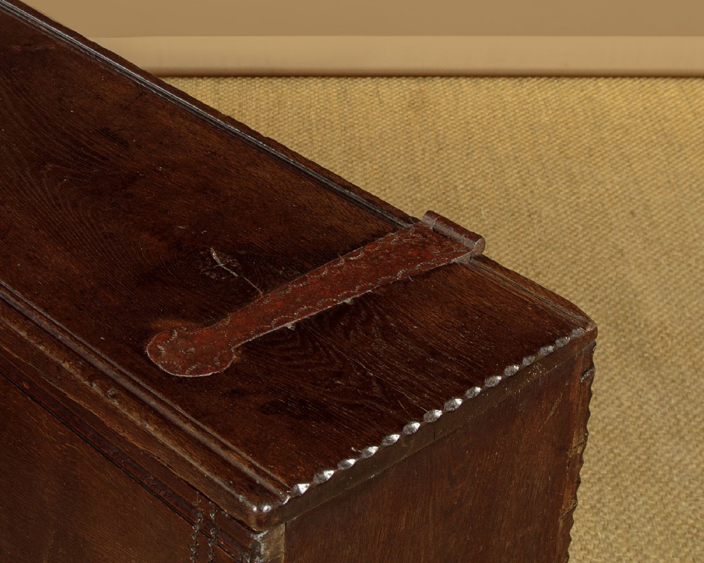 A long dark oak boarded sword chest featuring iron strap hinges and slab end supports. View VII