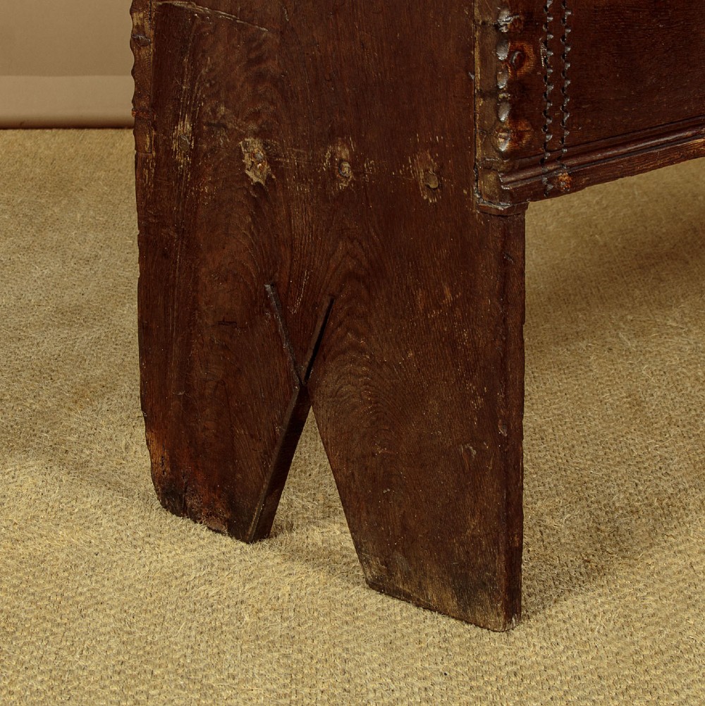A long dark oak boarded sword chest featuring iron strap hinges and slab end supports. View XII
