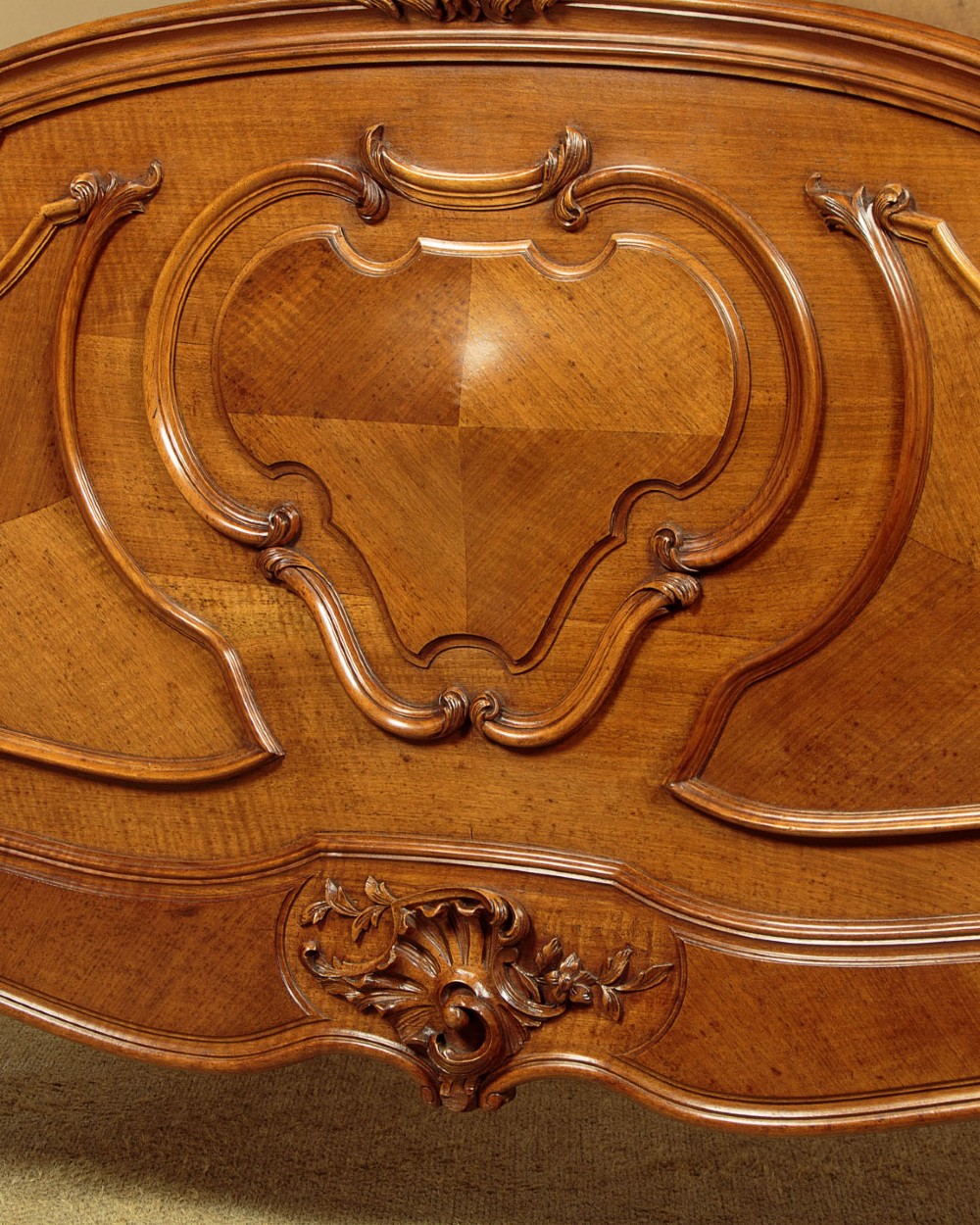 An antique French double bed frame crafted from carved walnut featuring serpentine edges, shell motifs, and book-matched veneered panels on the headboard and footboard. View VII