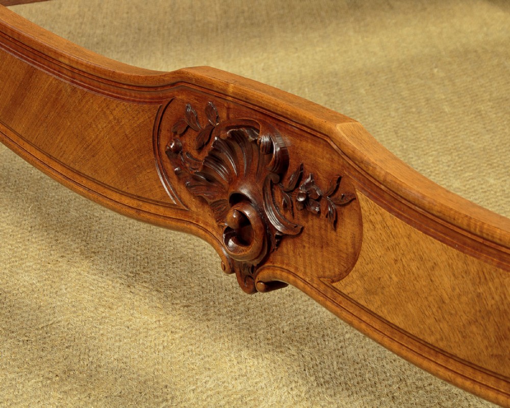 An antique French double bed frame crafted from carved walnut featuring serpentine edges, shell motifs, and book-matched veneered panels on the headboard and footboard. View XI