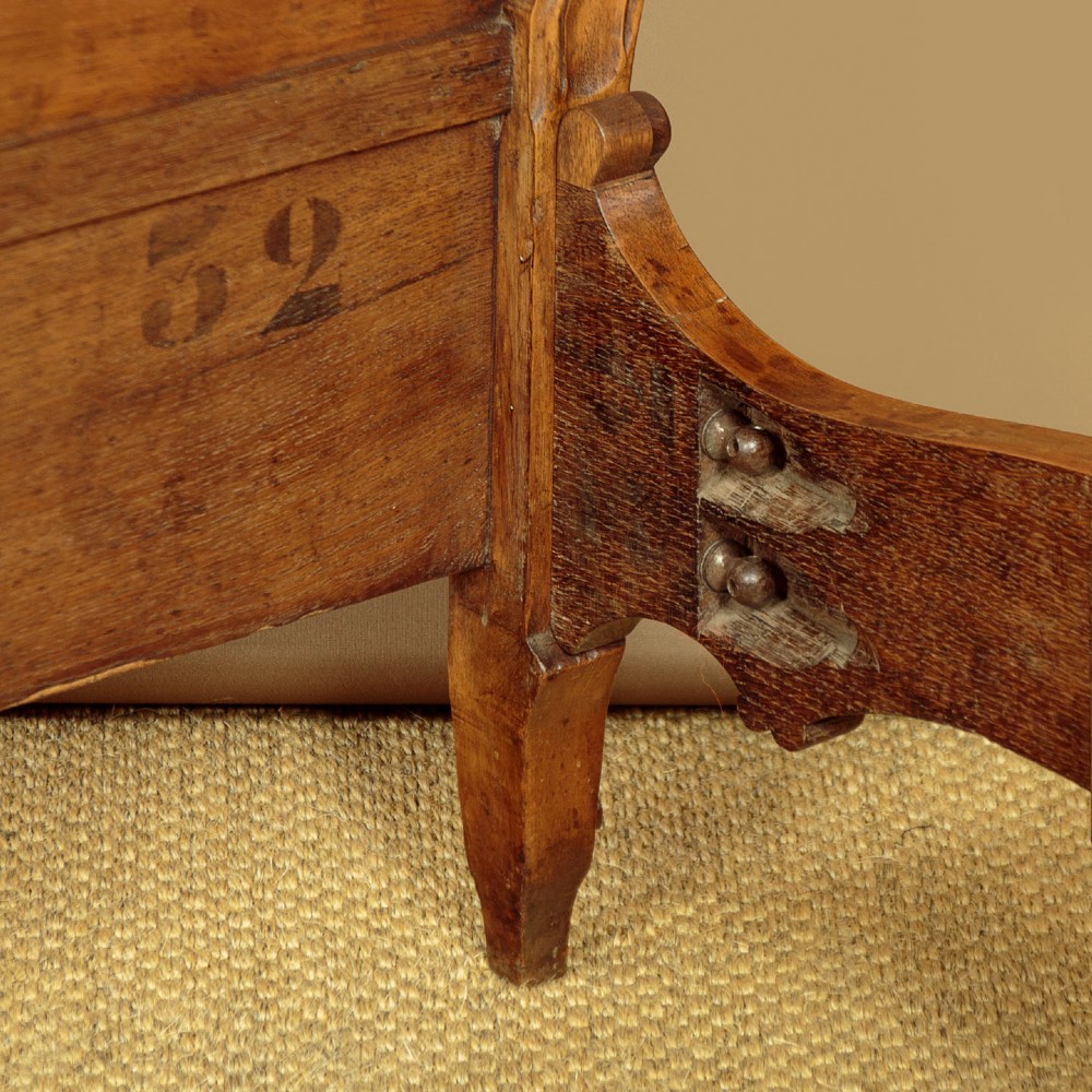 An antique French double bed frame crafted from carved walnut featuring serpentine edges, shell motifs, and book-matched veneered panels on the headboard and footboard. View XII