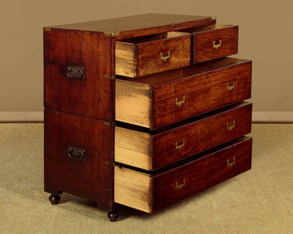 A Victorian mahogany military campaign chest featuring brass corner bindings, flush handles, two short drawers over three long drawers, resting on turned feet. View IV