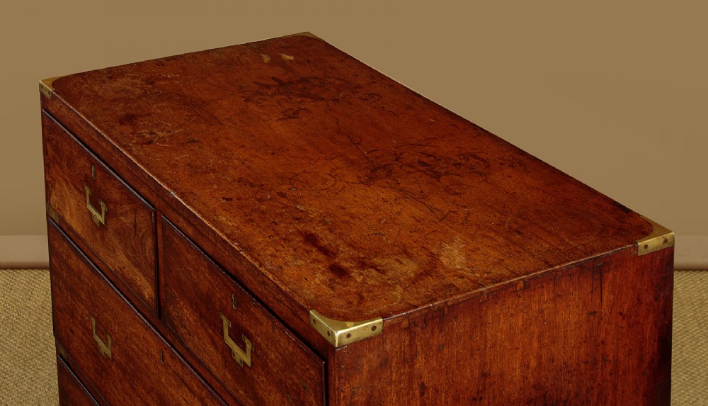 A Victorian mahogany military campaign chest featuring brass corner bindings, flush handles, two short drawers over three long drawers, resting on turned feet. View V